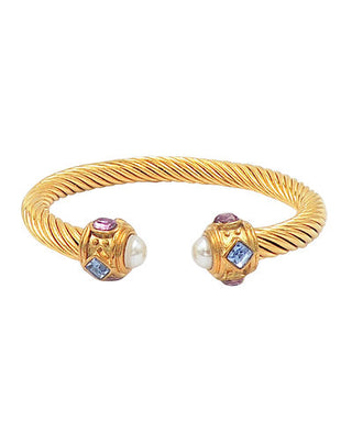 Gold bracelet with gemstone and pearl accents on a white background