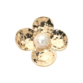 A gold flower-shaped brooch with a textured hammered finish and a central white faux pearl, shown on a plain white background.