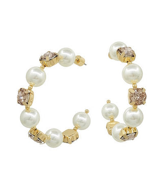 Pair of pearl and gold hoop earrings on a white background