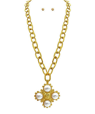 Gold necklace with a floral pendant featuring pearls on a white background
