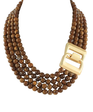 A multi-strand statement necklace made of brown wooden beads with a large, polished gold-tone square buckle, shown on a plain white background.