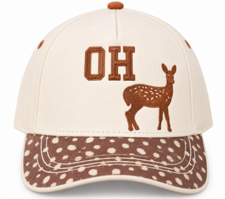 An off-white baseball cap with brown embroidered 'OH' lettering and a brown deer graphic on the front, featuring a brown and off-white polka dot patterned visor.