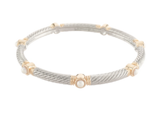 A silver-toned cable bangle bracelet with gold-toned decorative accents and a central white stone, shown on a plain white background.