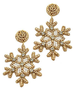 Gold and white beaded snowflake earrings on a white background