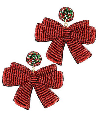 Red bow-shaped earrings with small round embellishments on a white background