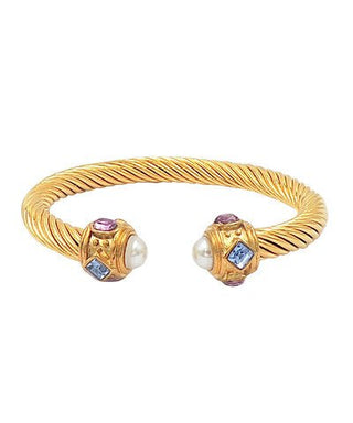 Gold bracelet with gemstone and pearl accents on a white background
