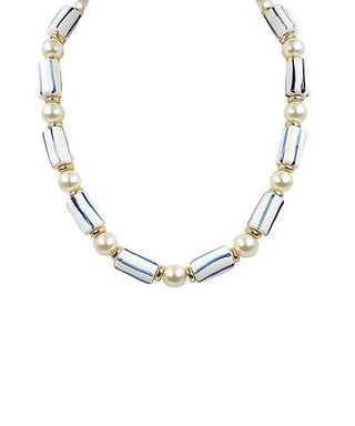 Necklace with alternating pearls and silver tubes on a white background